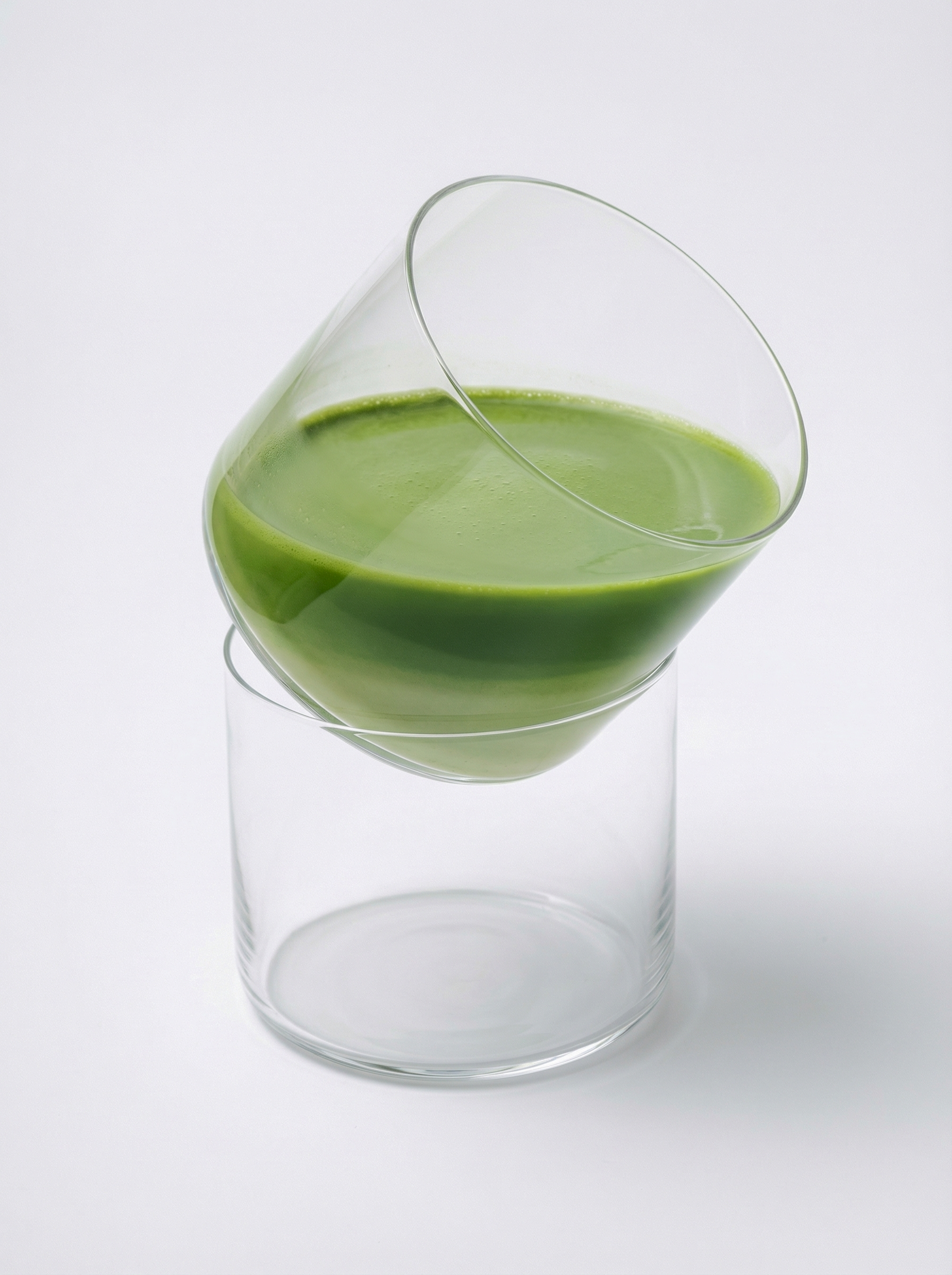 Green smooth matcha latte in a glass on a white background